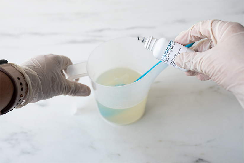 Adding liquid dye to melted soap base.